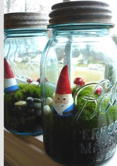 two mason jars filled with moss and little gnomes