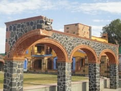 a stone building with arches and pillars in front of it