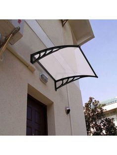 an awning on the side of a house in front of a door and window