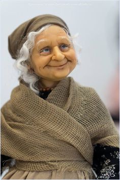 an old woman doll with white hair and blue eyes