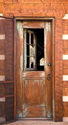 an old wooden door with a window in it