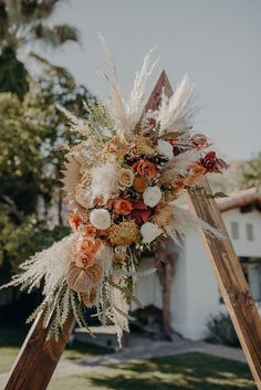 a wedding arch decorated with flowers and feathers