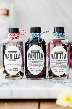 three bottles of vanilla are sitting on a table