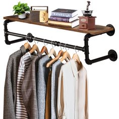 an iron pipe shelf with clothes hanging on it and a potted plant next to it