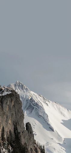 a snowboarder is standing on top of a mountain