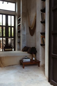 a bedroom with a bed, bookshelf and window