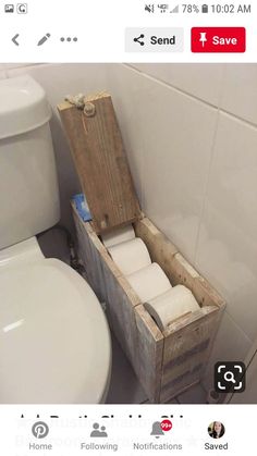 a wooden box filled with toilet paper next to a white toilet in a small bathroom