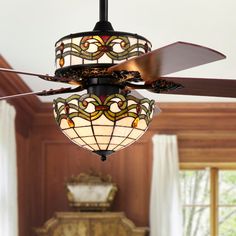 a ceiling fan with stained glass shades hanging from it's blades