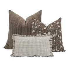 three pillows with different patterns on them, one in brown and the other in white