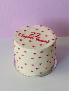 a white cake with red hearts on it