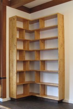 an empty bookcase in the corner of a room with wood trimmings on the walls