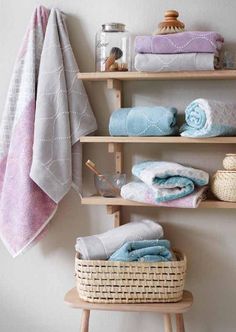 towels and other items are on shelves in the bathroom, along with baskets for storage