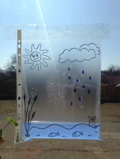 a clear plastic bag with blue and white drawings on the side, in front of a fence