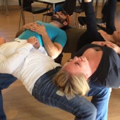 a group of people laying on top of each other in the middle of a room