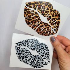 someone is holding up two stickers with leopard print on them and one has a kiss