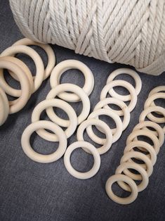 several different types of white rubber rings and spools next to a ball of twine