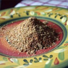 a pile of brown stuff sitting on top of a yellow and red plate next to a checkered table cloth