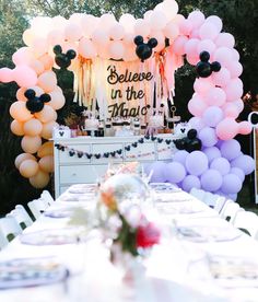 a table set up for a party with balloons