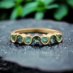 an image of a gold ring with green stones