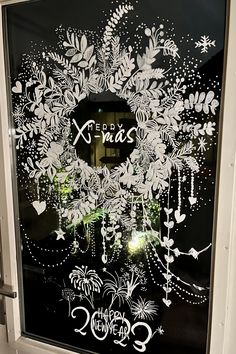 a decorated glass door with the words x - mas written in white letters on it