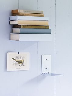 books are stacked on top of each other in front of a wall mounted light switch