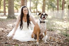 a bride and her dog are sitting in the woods