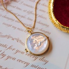 Introducing our unique round locket pendant that combines classic and modern design elements! One side features a beautiful piece of natural mother of pearl while the other side showcases delicate hollow patterns in gold vermeil. This locket opens up to reveal a small space where you can keep a special photo, message, or perfumed ball close to your heart. The natural patterns and elegant glow of each piece of mother of pearl are one-of-a-kind, making this pendant truly unique. The necklace is ad Luxury Round Pendant Locket Necklace For Wedding, Luxury Round Pendant Necklace For Keepsake, Luxury Classic Medallion Locket Necklace, Cheap Antique Round Pendant Necklace, Unique Locket Necklace Pearl, Luxury Elegant Locket Pendant Necklace, Mother Of Pearl Necklace Locket, Unique Locket Necklace, Unique Locket