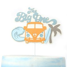 a cake topper that says the big one with a bus and palm trees on it