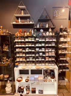 a display case filled with lots of different types of donuts and pastries in glass cases