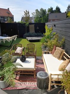 an outdoor patio with chairs, tables and rugs