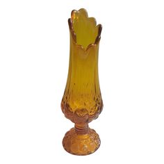 a yellow glass vase sitting on top of a table