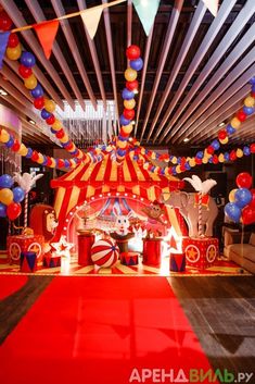 a circus themed birthday party with red, white and blue balloons hanging from the ceiling