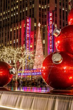 the radio city christmas tree is lit up in red and silver balls with lights on them