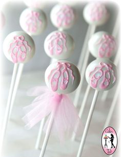 pink and white lollipops with bows on them are sitting on a table