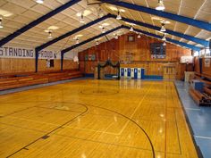 an indoor basketball court with hard wood flooring