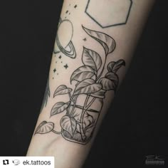 a black and white photo of a tattoo on someone's arm that has a plant growing out of it