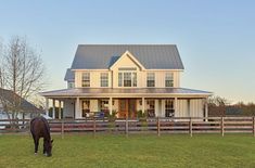 a horse grazes in front of a large house