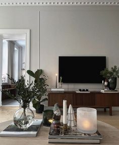 a living room filled with furniture and a flat screen tv on top of a wooden table