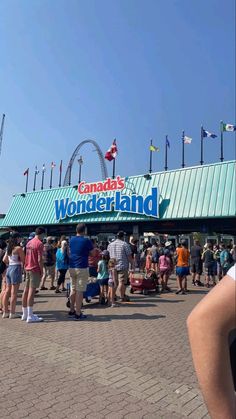 a crowd of people standing in front of a building with a sign that reads canada's wonderlandland