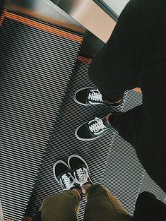 a person standing on an escalator with their feet in the air next to them