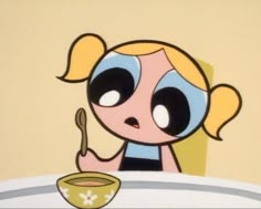 a cartoon character is sitting at a table with a bowl and spoon in front of her