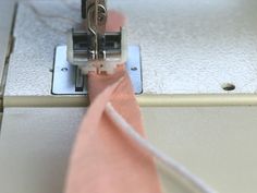 the sewing machine is working on the pink ribbon that has been sewned into it