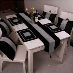 a dining room table with black and white chairs