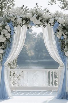 a white and blue wedding arch decorated with flowers