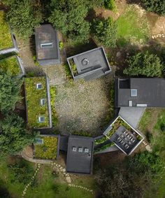 an aerial view of a house surrounded by trees and grass in the middle of it