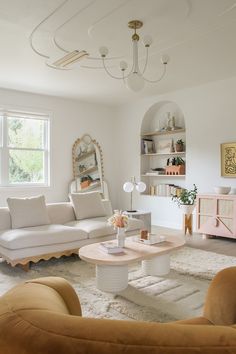 a living room filled with furniture and a white rug on top of a hard wood floor