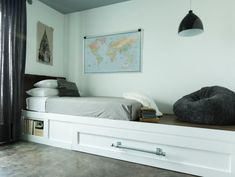 a bed sitting on top of a wooden shelf next to a window