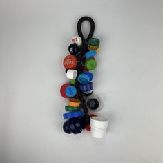 a bunch of different colored cups and spoons on a white surface with a black handle