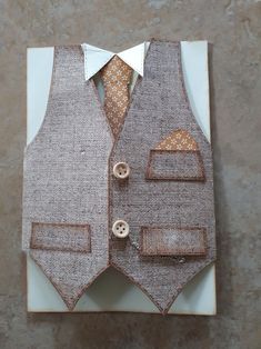 a piece of cloth with buttons on the lapel and vest is sitting on a white plate