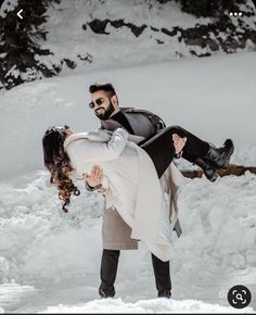 a man holding a woman in the snow